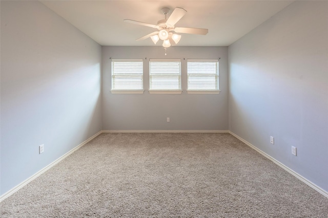 spare room with a healthy amount of sunlight, carpet, ceiling fan, and baseboards