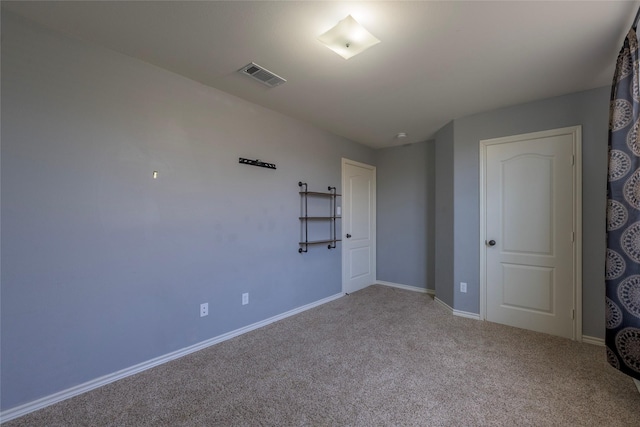 interior space with baseboards, visible vents, and light colored carpet