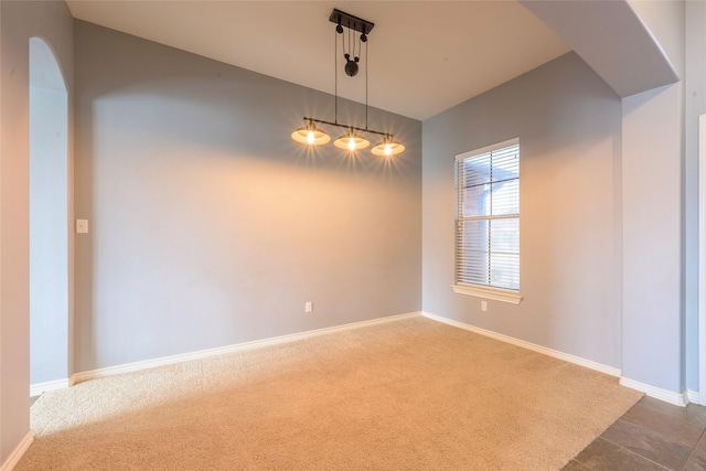 carpeted spare room featuring baseboards