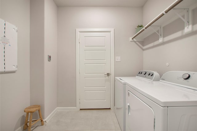 laundry room with laundry area, light tile patterned floors, baseboards, and separate washer and dryer