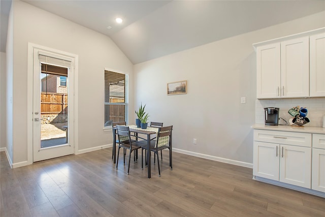 dining area featuring light wood-style flooring, baseboards, vaulted ceiling, and recessed lighting