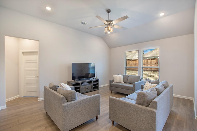 living area with light wood finished floors, visible vents, a ceiling fan, vaulted ceiling, and baseboards