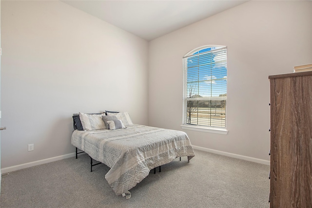 bedroom featuring light carpet and baseboards