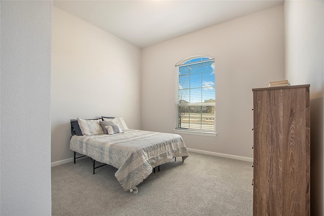 bedroom featuring light carpet and baseboards