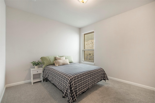 bedroom with light carpet and baseboards