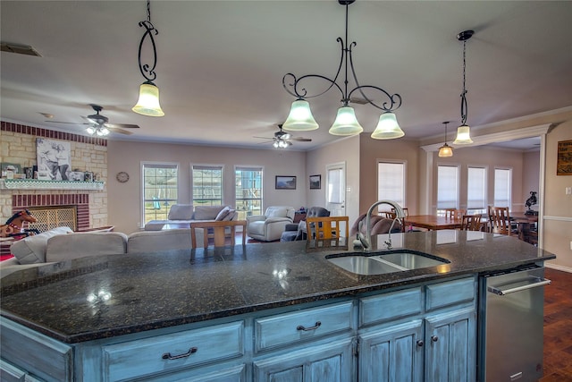 kitchen featuring open floor plan, hanging light fixtures, a sink, and visible vents