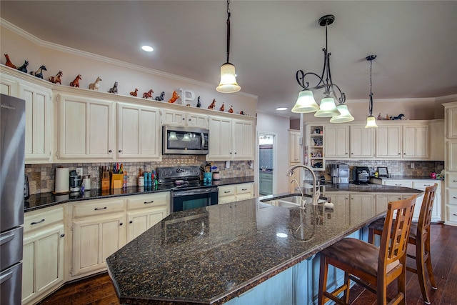 kitchen featuring stainless steel appliances, a sink, dark wood-style floors, a center island with sink, and pendant lighting