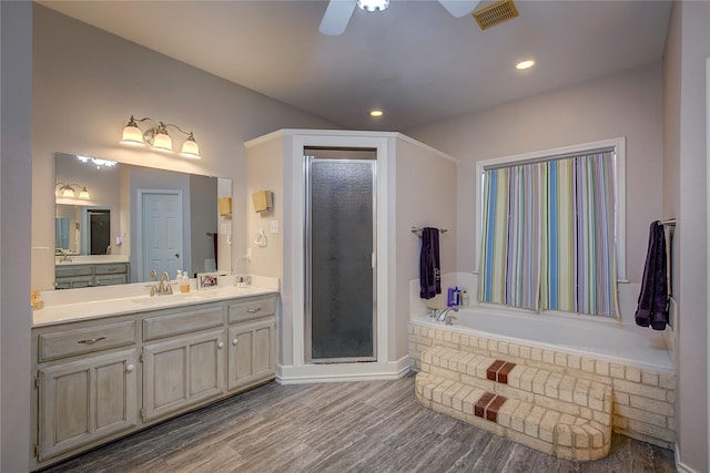 full bathroom with a stall shower, visible vents, a ceiling fan, wood finished floors, and a bath