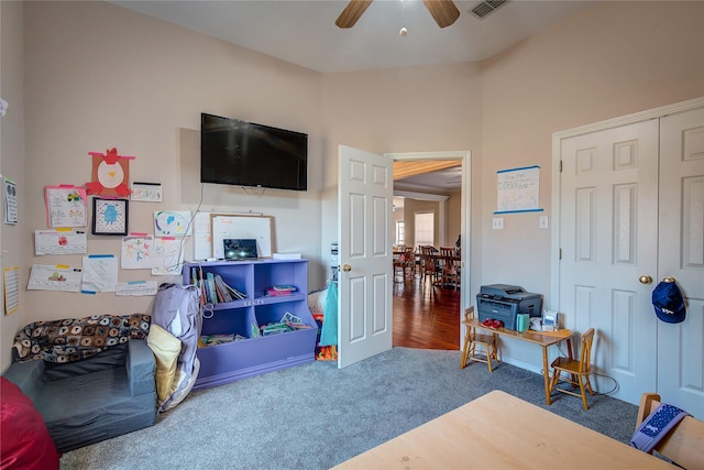 playroom with ceiling fan, carpet floors, vaulted ceiling, and visible vents