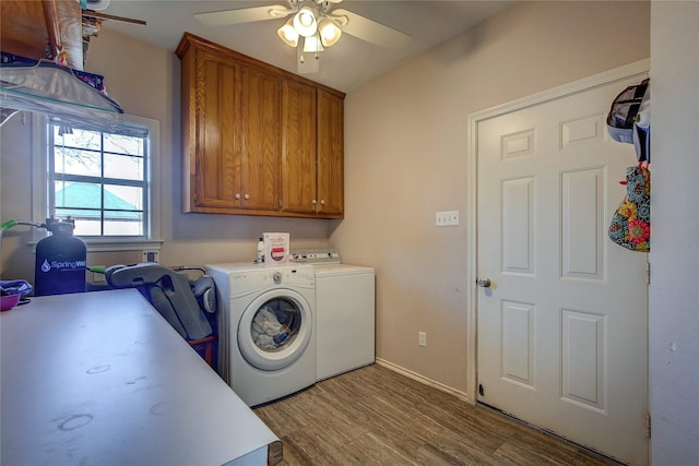 laundry area with cabinet space, light wood-style flooring, ceiling fan, separate washer and dryer, and baseboards