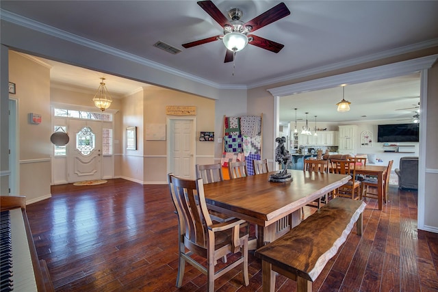 dining room with dark wood-style floors, visible vents, crown molding, and ceiling fan with notable chandelier