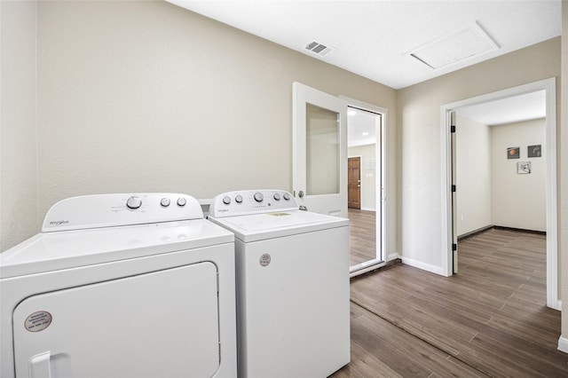 laundry area featuring laundry area, visible vents, baseboards, washer and dryer, and dark wood finished floors