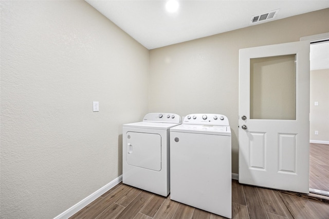 laundry room with visible vents, wood finished floors, laundry area, independent washer and dryer, and baseboards