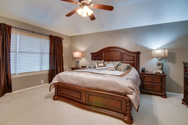 bedroom featuring lofted ceiling, baseboards, a ceiling fan, and light colored carpet