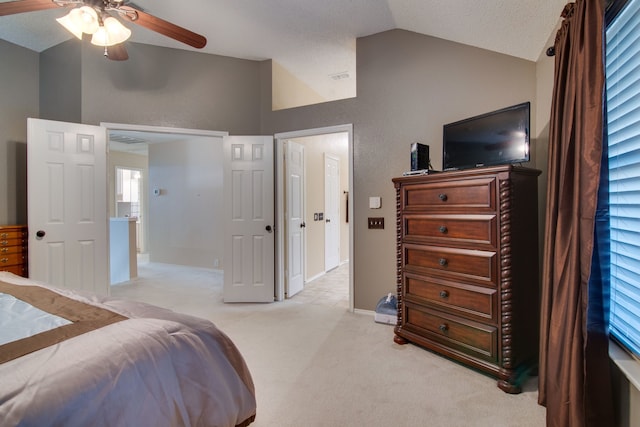 bedroom with light carpet, baseboards, ceiling fan, vaulted ceiling, and a textured ceiling