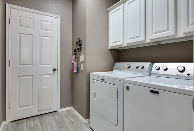 laundry area featuring cabinet space, wood tiled floor, baseboards, and washer and dryer