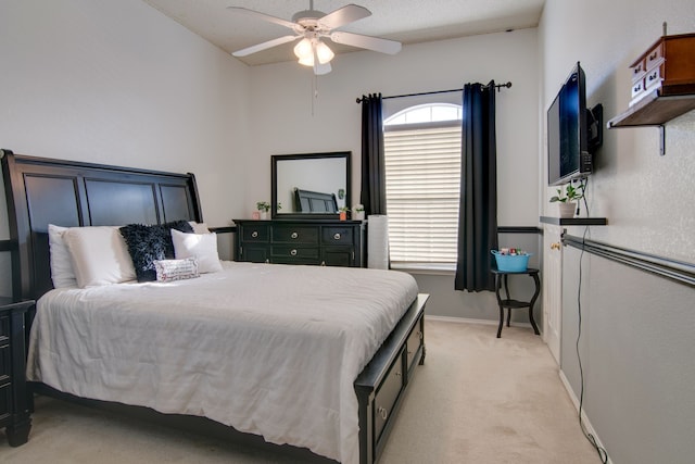 bedroom featuring light carpet, baseboards, and a ceiling fan