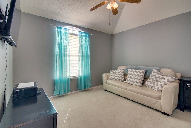 living room with ceiling fan, vaulted ceiling, a textured ceiling, and light colored carpet