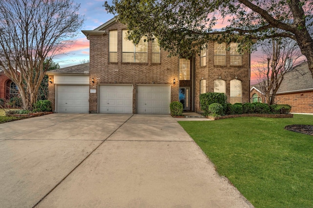 view of front of home featuring a garage, brick siding, driveway, and a lawn