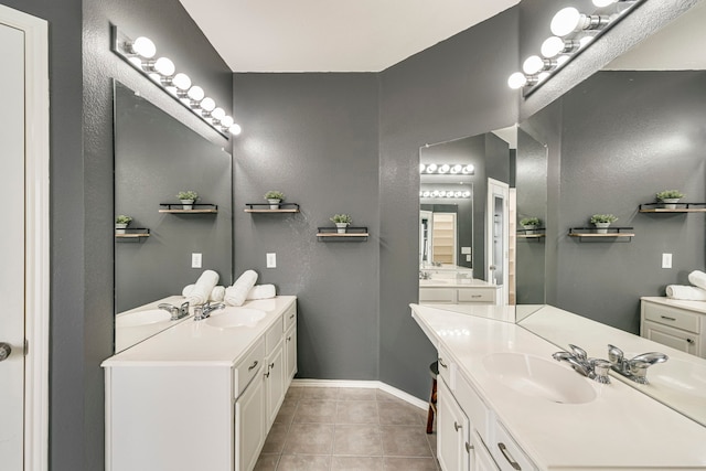 full bathroom featuring tile patterned flooring, two vanities, and a sink