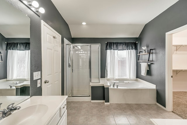 bathroom featuring a garden tub, lofted ceiling, a shower stall, vanity, and tile patterned floors