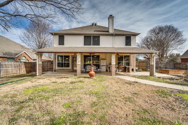 rear view of property featuring a ceiling fan, a patio area, a fenced backyard, and a chimney