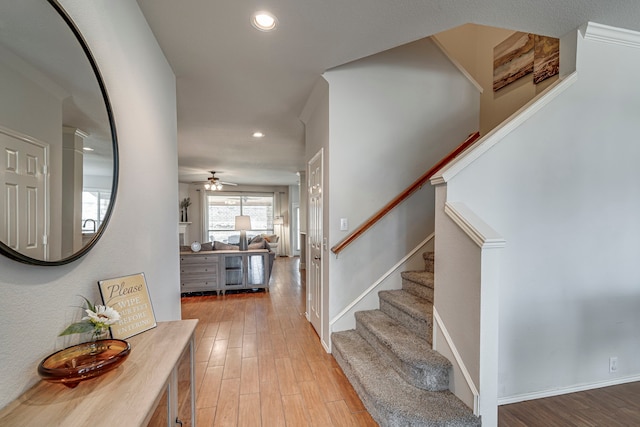 entryway with baseboards, light wood finished floors, stairway, and recessed lighting