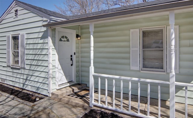 entrance to property with a shingled roof