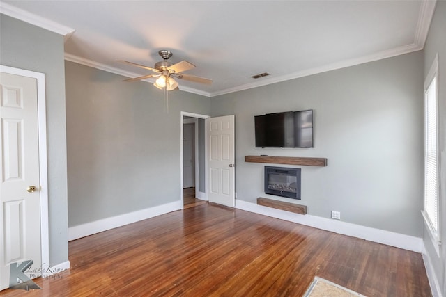 unfurnished living room with a glass covered fireplace, visible vents, and crown molding