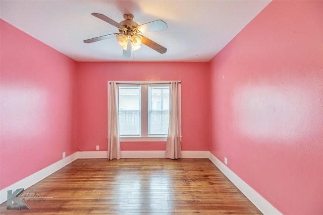 spare room featuring baseboards, ceiling fan, and light wood finished floors