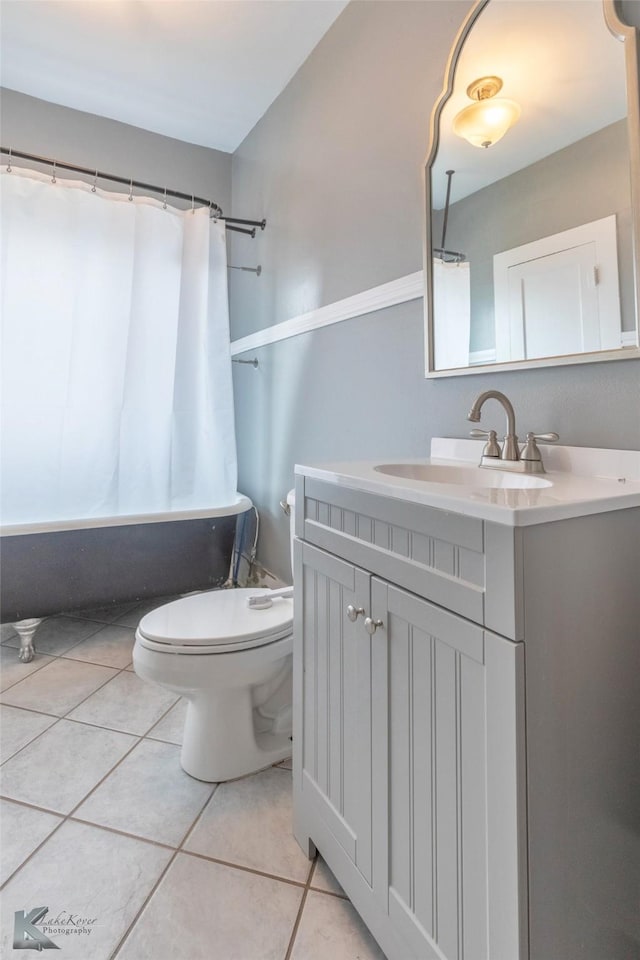 full bath featuring toilet, tile patterned flooring, vanity, and shower / tub combo with curtain