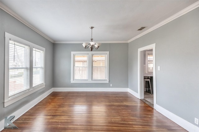 empty room featuring an inviting chandelier, baseboards, dark wood-style flooring, and ornamental molding