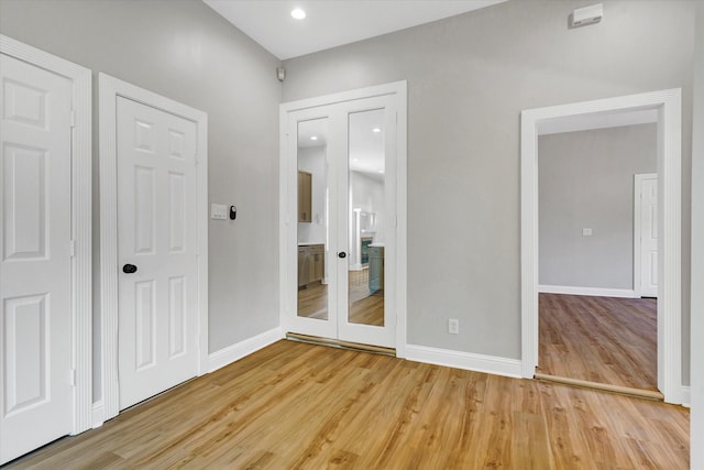 unfurnished bedroom featuring light wood-style flooring, baseboards, and recessed lighting