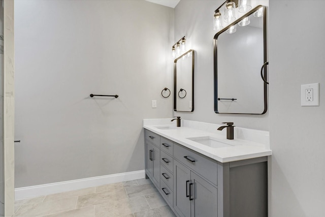 bathroom featuring double vanity, a sink, and baseboards