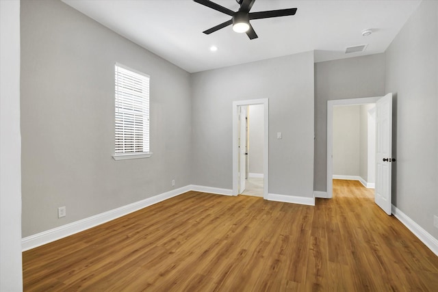 unfurnished bedroom with ceiling fan, wood finished floors, visible vents, and baseboards