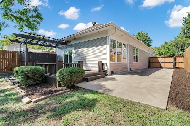 back of property with a deck, a patio area, a fenced backyard, and a pergola