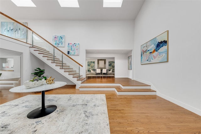 6005 Northwood Rd, Dallas, TX 75225 - entryway with a high ceiling, baseboards, wood finished floors, a skylight, and stairway