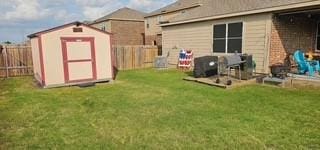 view of yard with a fenced backyard, a shed, and an outdoor structure