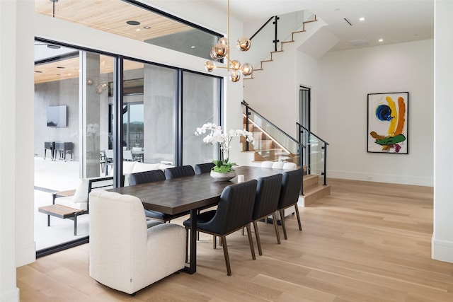 dining space featuring light wood finished floors, baseboards, stairs, a notable chandelier, and recessed lighting