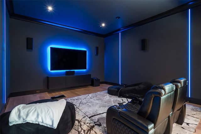 cinema room featuring crown molding, baseboards, and wood finished floors