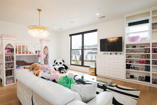 living room with light wood finished floors, recessed lighting, visible vents, and a notable chandelier