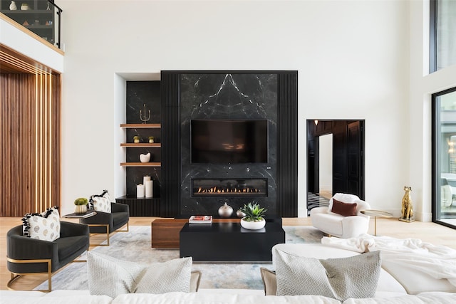 living room featuring a high end fireplace and a towering ceiling