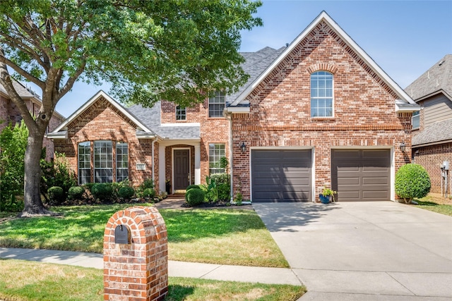 traditional home featuring roof with shingles, a front yard, concrete driveway, and brick siding