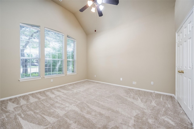 empty room featuring lofted ceiling, light colored carpet, ceiling fan, and baseboards