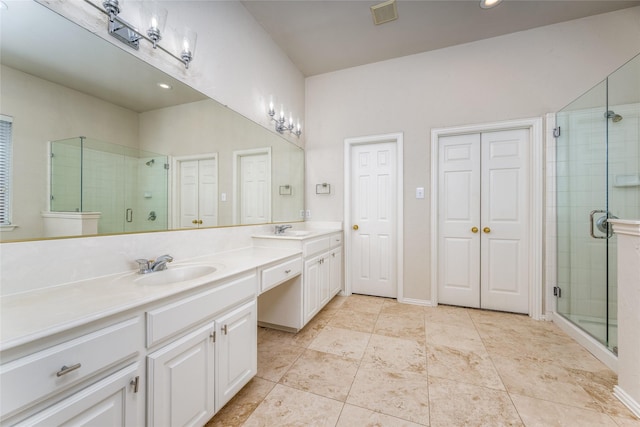 bathroom featuring visible vents, a sink, a shower stall, and double vanity