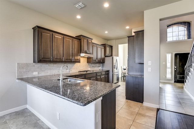 kitchen with visible vents, appliances with stainless steel finishes, a sink, a peninsula, and under cabinet range hood