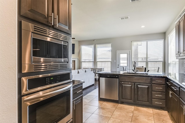 kitchen with visible vents, appliances with stainless steel finishes, dark brown cabinets, and a sink