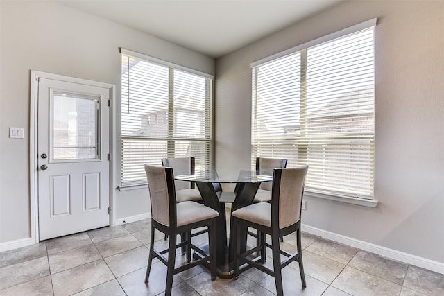 dining space featuring light tile patterned flooring and baseboards