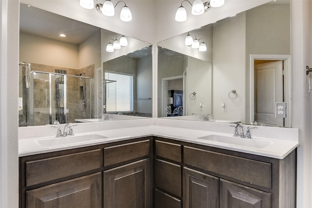 ensuite bathroom with double vanity, ensuite bath, a shower stall, and a sink