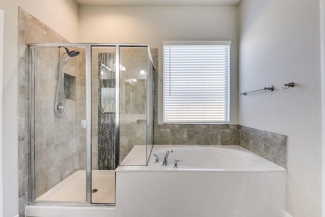 bathroom with a stall shower and a bath